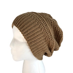 May include: A brown crocheted beanie hat with a slouchy fit. The hat is made with a textured stitch and has a simple, classic design.