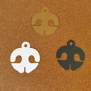 May include: Three paper ornaments in the shape of a bell. The ornaments are brown, white, and black.