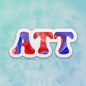 May include: A sticker with the letters "ATT" in red and blue marbled design, outlined in white. The sticker is on a light blue and green tie-dye background. The text "@TheTieDyeDog" is at the bottom.