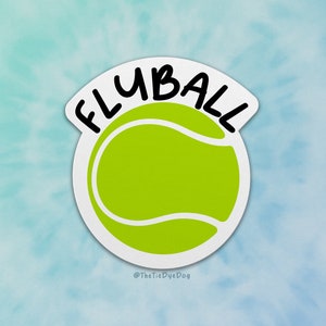 Op de afbeelding: Een witte sticker met een groene tennisbal en de tekst "FLYBALL" in zwarte letters. De sticker heeft de tekst "@TheTieDyeDog" onderaan.