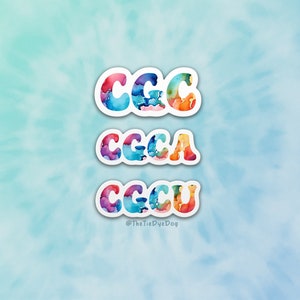 May include: Three colorful stickers with the letters "CCC", "CCCA", and "CCCU" in a rainbow watercolor style. The stickers are on a light blue background with a tie-dye pattern. The text "@TheTieDyeDog" is at the bottom of the image.