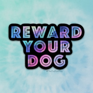 May include: A sticker with a tie-dye effect in shades of pink, blue, and purple. The sticker says "Reward Your Dog" in black outlined letters. The text "@TheTieDyeDog" is in smaller letters below the main text.