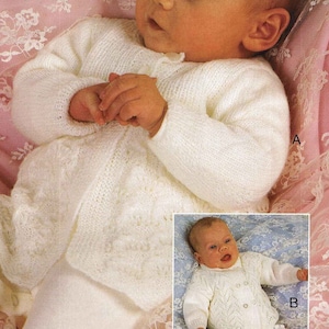 May include: A white knitted baby cardigan with a button fastening and a delicate lace pattern. The cardigan is shown on a baby lying on a pink lace blanket. The text "12-16" is visible in the top right corner of the image.
