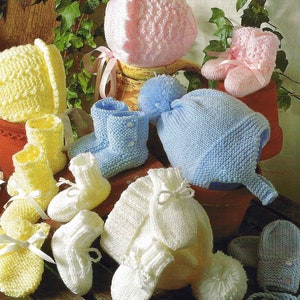 May include: A set of knitted baby items in pink, yellow, white, and blue. The set includes a hat, booties, and mittens.