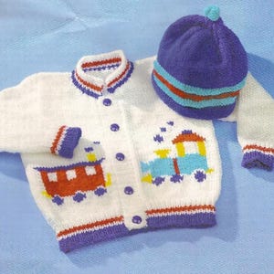May include: White knitted cardigan with a train design and blue buttons. The cardigan has a purple and red trim. A matching blue knitted hat with a white and red trim is included.