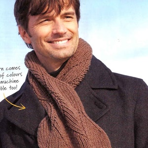 May include: A man wearing a brown knitted scarf over a dark coat. The scarf is made of a textured yarn. Text on the image says, "This yarn comes in loads of colours and is machine washable too!"
