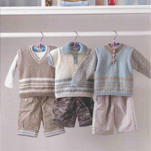 Puede incluir: Tres jerséis de punto para niños, colgados de perchas. Los jerséis son de rayas marrones, blancas y azules. Los jerséis tienen una talla de 36-61 cm (14-24 pulgadas).