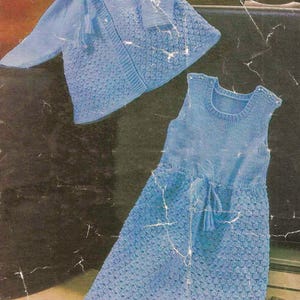 May include: A blue knitted baby dress and matching hooded jacket. The dress has a tie at the waist and the jacket has a hood with a tie.