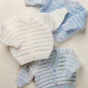 Puede incluir: Tres cárdigans de punto para bebé en blanco, azul claro y una mezcla de blanco y azul claro. Los cárdigans tienen un cierre de botones en la parte delantera y un diseño sencillo.