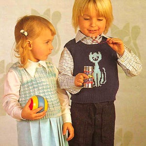 May include: Two children in vintage clothing. A girl wears a light blue pleated skirt, a white collared shirt, and a blue and white patterned vest, holding a colorful ball. A boy wears a navy blue sweater with a cat design and holds a can of soap bubbles.
