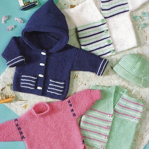 May include: A selection of hand-knitted baby garments in shades of blue, pink, and green. The image shows a navy blue hooded jacket, a pink sweater, and a green hat. There are also white and green striped sweaters.