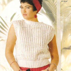 May include: White sleeveless knitted top with a ribbed texture. The top has a round neckline and is worn with red pants and a red headband.
