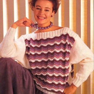 May include: A white knitted sweater with a purple, pink, and white wavy pattern. The sweater has a boat neck and long sleeves. "32-40 inch 81-102 cm Three Sizes" is written at the top of the image.