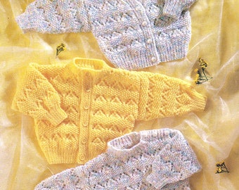 May include: Three knitted baby cardigans in different colors: white with multi-colored flecks, yellow, and light blue with multi-colored flecks. The cardigans have a lacy pattern and button closures.