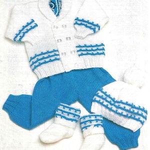 May include: A white knitted baby outfit with blue accents. The outfit includes a cardigan, pants, booties, and a hat.