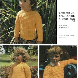 May include: A knitting pattern leaflet numbered 1023 for a yellow long-sleeved sweater. The text includes BABYKIN DK, BEAULON DK, SUPERBLEND DK, MACHINE WASHABLE, and 20 to 26 inch chest (51 to 66 cm). The images show children wearing the sweater.