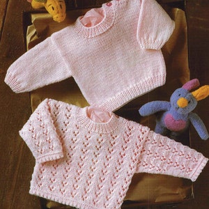 May include: Two pink knitted baby sweaters, one with a simple design and the other with a lacy pattern.
