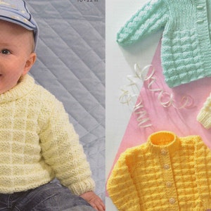 Pode incluir: Três suéteres de tricô para bebê em amarelo, verde claro e branco. Os suéteres têm um padrão de ponto texturizado e são mostrados em um fundo rosa.