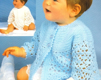 May include: A baby wearing a light blue crocheted cardigan with a white crocheted lace trim. The cardigan has a button closure and is made with a delicate open stitch pattern.