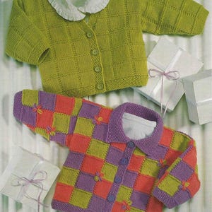 May include: Two knitted baby cardigans. The top cardigan is lime green with a white ruffled collar and matching buttons. The bottom cardigan is a patchwork of orange, purple, and green squares, with purple buttons and small flower accents.