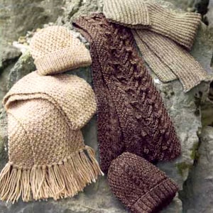 May include: A set of four knitted hats and scarves in brown and beige. The hats and scarves are made of a soft, chunky yarn and have a textured knit.