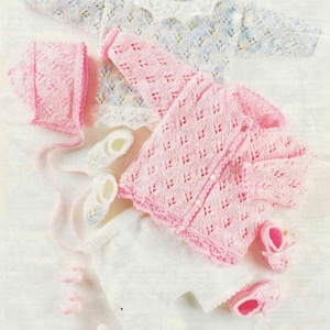 May include: A set of knitted baby clothes in pink and white, including a cardigan, hat, and booties.