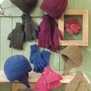 Peut inclure: Une collection de bonnets et de gants tricotés de différentes couleurs, dont vert olive, bordeaux, bleu et rose. Les chapeaux comprennent des bonnets et un style de trappeur. Les gants sont de style doigts et mitaines. Le signe dans l'image indique "Tailles enfants et adultes."