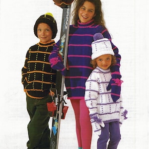 Puede incluir: Tres niños con conjuntos de invierno de punto, que incluyen suéteres, gorros y mitones. Un niño sostiene esquís. Los conjuntos presentan rayas y patrones en negro, morado, blanco y naranja. Los niños llevan leggings y botas.