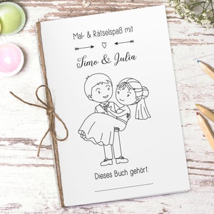 Puede incluir: Un libro para colorear en blanco y negro con una ilustraci&oacute;n de dibujos animados de una pareja. El libro tiene el texto "Mal & R&auml;tselspass mit Timo & Julia" y "Dieses Buch geh&ouml;rt:" en la portada.