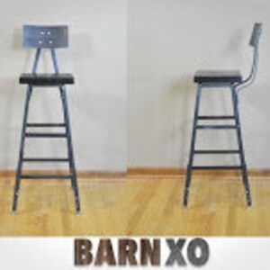 May include: Black metal bar stool with a black wooden seat and a metal back rest. The stool has a simple design with four legs and a footrest.
