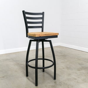 May include: Black swivel bar stool with a wood seat and a slatted back.