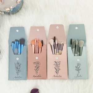 Könnte beinhalten: Vier Make-up-Pinsel-Sets in verschiedenen Farbtönen mit einem Blumendesign und dem Namen "Amelie" auf jedem Etui.