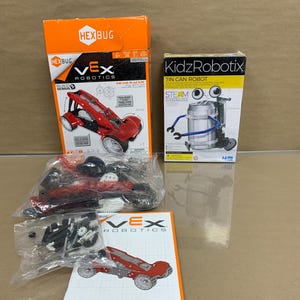 May include: Two STEM toy kits for kids. A red and black gear racer kit from VEX Robotics and a tin can robot kit from KidzRobotix. Both kits include instructions and parts to build the robot.