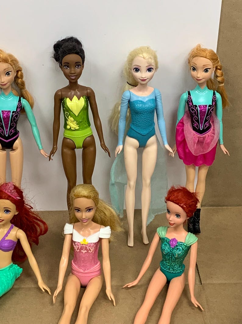 K&ouml;nnte beinhalten: Eine Sammlung von Modepuppen mit verschiedenen Charakteren. Die Puppen tragen farbenfrohe Outfits, darunter Badeanz&uuml;ge und Kleider. Die Puppen haben lange Haare und sind in verschiedenen Posen dargestellt. Die Puppen sind aus Kunststoff und f&uuml;r Kinder konzipiert.