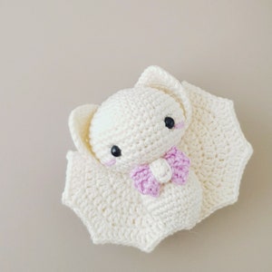 May include: A white crocheted bat with pink bow, a handmade plush toy with black eyes.
