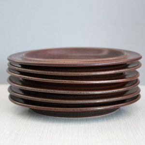 以下が含まれることがあります： 斑点のある釉薬をかけた茶色のセラミックプレートが8枚重ねられています