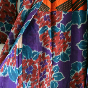 Op de afbeelding: Een paarse en turquoise kimono met een bloemenpatroon. De kimono is gemaakt van een zachte, zijdeachtige stof en heeft een traditioneel Japans ontwerp.