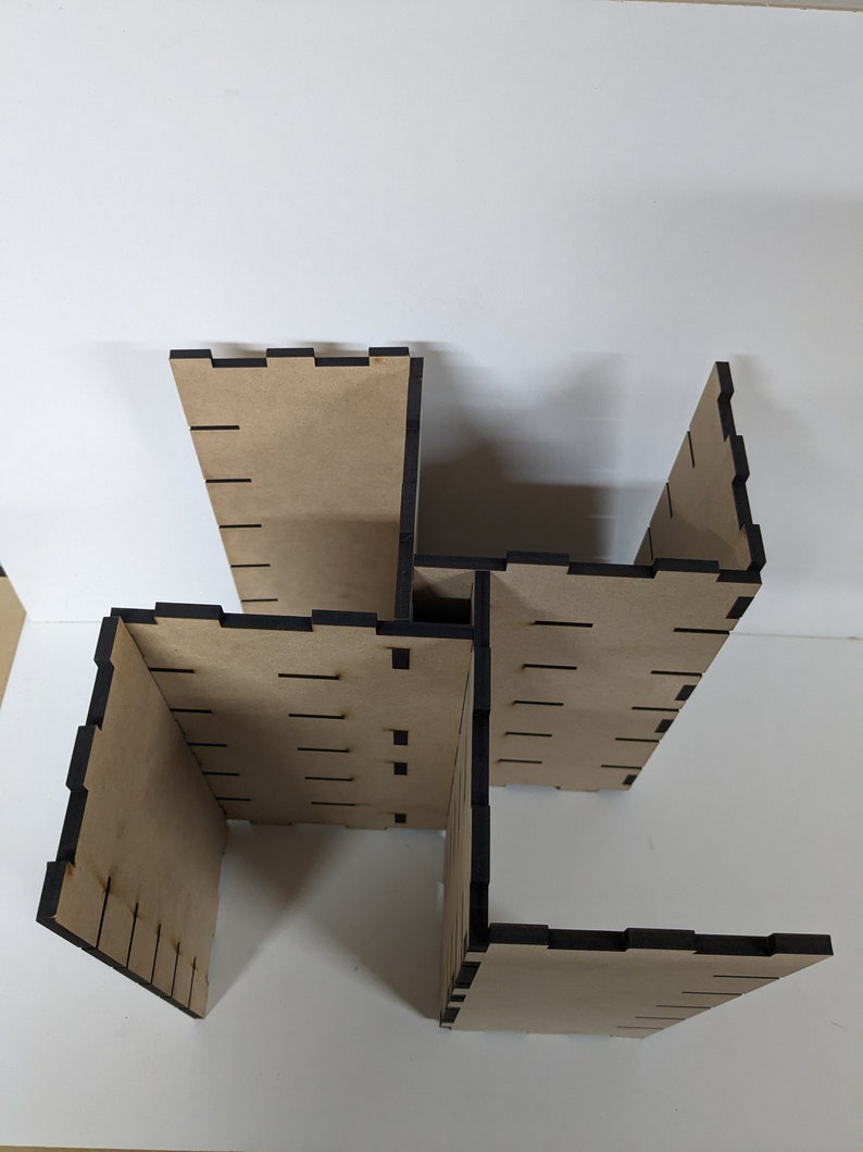 May include: A wooden box with four sides, each side has a black border and is made of plywood. The box is assembled in a way that creates a square shape with an open center.