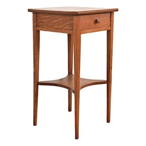 May include: A small, wooden side table with a single drawer and a lower shelf. The table is made of a warm, reddish-brown wood and features a square top and slender legs. The drawer has a small, square wooden knob.