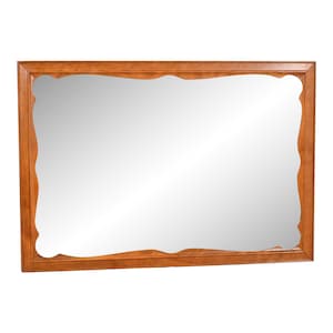 May include: A large, rectangular mirror with a wood frame. The frame has a wavy, organic shape and is a light brown color.