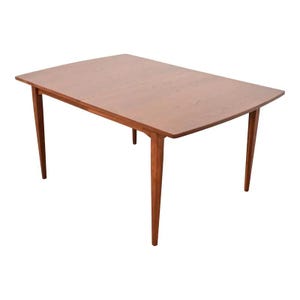 May include: A rectangular wooden dining table with a light brown finish. The table has four tapered legs and a smooth surface. The table is approximately 60 inches long and 36 inches wide.