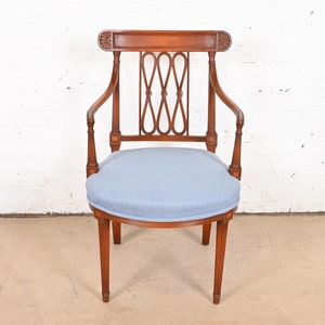 May include: A wooden armchair with a light blue upholstered seat and a carved back.