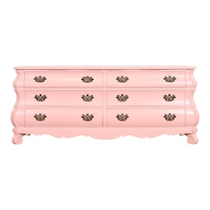 May include: A six-drawer dresser with a light pink finish and ornate brass hardware. The dresser has a curved, scalloped front and sits on four short legs.