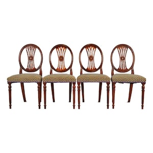 May include: Four antique wooden chairs with oval backs and patterned seats. The chairs have dark brown frames, decorative back carvings, and checkered fabric seats. The legs are turned and the chairs are set against a white background.