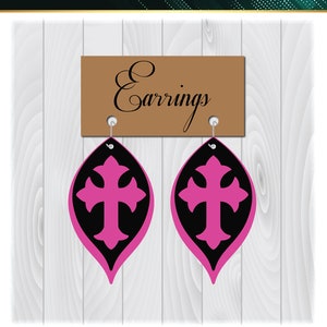 May include: A digital download of a pair of pink and black earrings with a cross design. The earrings are labeled "Earrings" on a brown sign. The text "CRAZY SALE Premium Design Only $0.99 SVG DXF PNG Cutting File" is at the top of the image. The text "Follow us on Pinterest We are going to be giving away FREE Designs Daily" is at the bottom of the image.