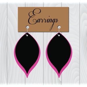 Pode incluir: Um par de brincos pretos e rosa em forma de l&aacute;grima pendurados em uma placa marrom que diz "Earrings".
