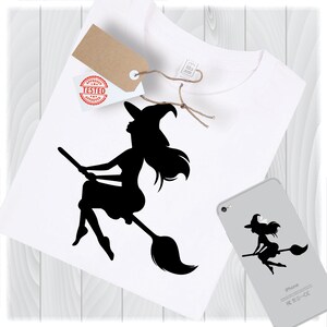Könnte beinhalten: Schwarze Silhouette einer Hexe, die auf einem Besen fliegt. Die Hexe trägt einen spitzen Hut und hat langes, fließendes Haar. Das Bild ist auf einem weißen T-Shirt.