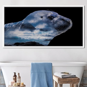 May include: A framed art print featuring a gray seal with a double exposure of a seascape. The seal's head and body are visible against a black background. The seascape includes ocean waves, rocks, and cloudy skies, creating a unique artistic effect.