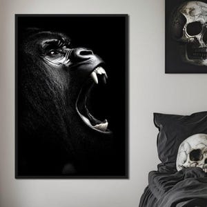 Op de afbeelding: Zwart-wit ingelijste print van een brullende gorilla, met gedetailleerde vachttextuur en open mond met zichtbare tanden. De donkere achtergrond benadrukt de kenmerken van de gorilla. De afbeelding maakt deel uit van een kunstcollectie.