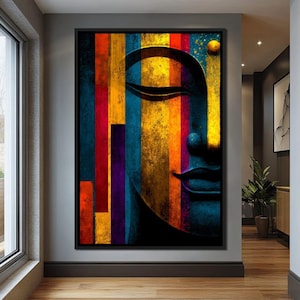 May include: A framed abstract art print featuring a serene Buddha face. The artwork uses vertical stripes of vibrant colors including red, orange, yellow, blue, and purple. The Buddha's face is a deep blue, with closed eyes and a subtle smile.